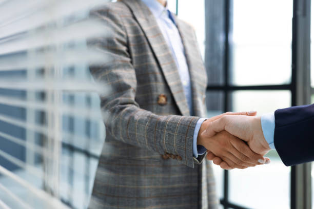 istock Two diverse professional business men executive leaders shaking hands at office meeting. 1492782396