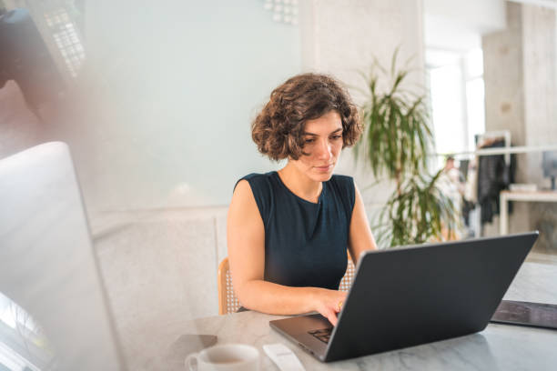 istock Caucasian Businesswoman Working In A Modern Office Using Laptop 1492787496