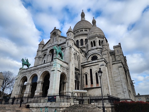 The Basilique du Sacré Coeur sits atop La butte Montmartre, a white marble church. It is a major tourist attraction. Each year, tourists visit the beauty of this cathedral. Paris, France 2023-03-30