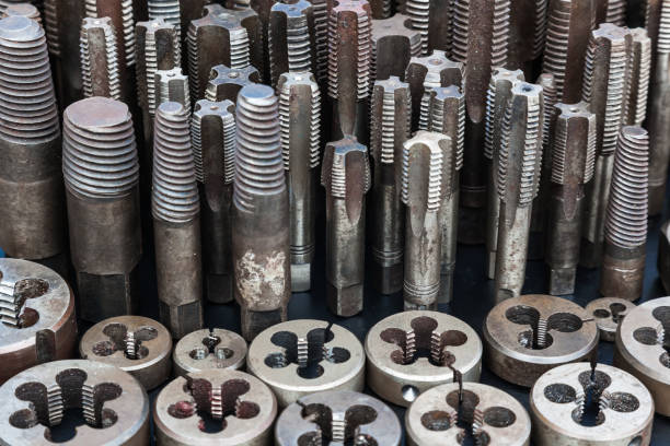 Taps and dies for metal threading. Tools for cutting external and internal threads, close-up.Taps and dies for metal threading. Tools for cutting external and internal threads, close-up.