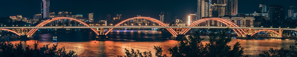 The panoramic view of Wenhui Bridge with its bright night illumination. Liuzhou, China.