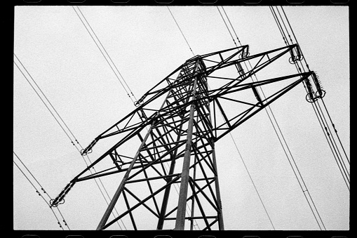 A low angle view of power lines against a black and white backdrop