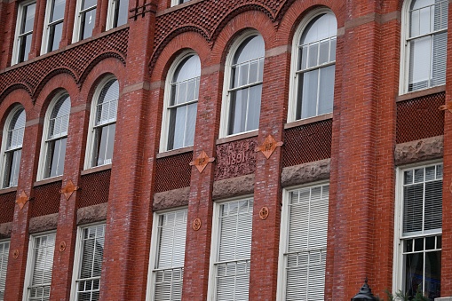 An exterior of an old building in an urban area with arched windows