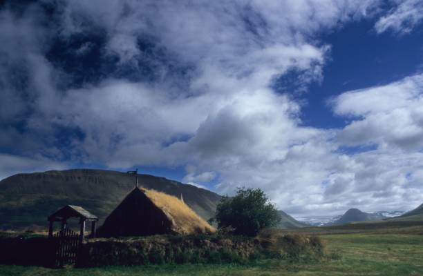 istock Old barn sits in a green field surrounded by a mountain 1492798025