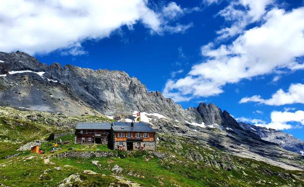 istock Small mountain cabin is in the mountains with green grass 1492798107