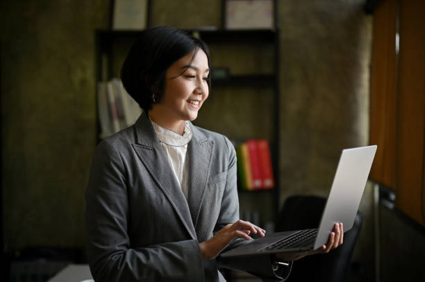 istock A happy Asian businesswoman leaning on her table and using her portable laptop computer. 1492798646