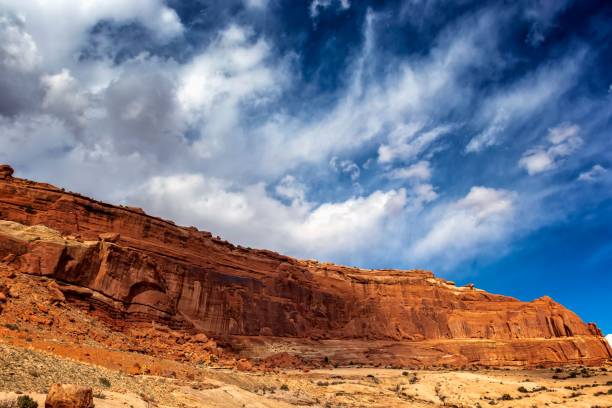 istock Desert landscape with a towering sandstone rock formation against a blue sky with clouds. 1492798787