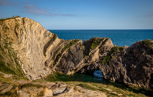 A stunning coastal landscape featuring a rocky cliff and waters in Stair Hole, Dorset, England