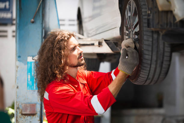 istock Technician man working in auto service with lifted vehicle, Auto mechanic working in garage, Car repair and maintenance 1492799715