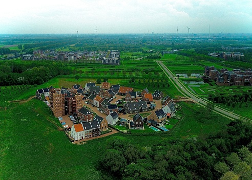 Aerial view of a vibrant small town, featuring green fields and residential homes nestled in the landscape