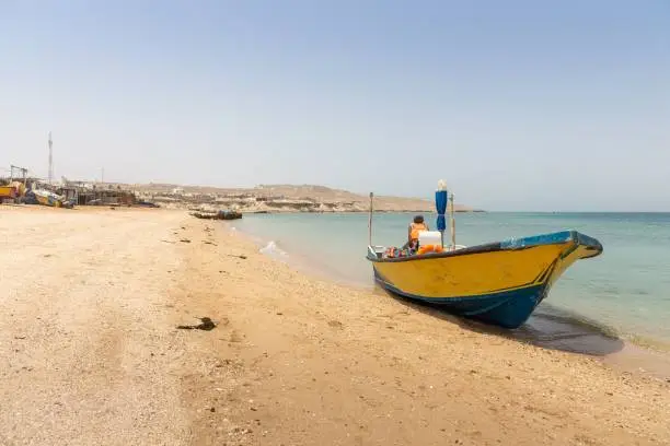 A yellow boat on the shoreline of a beach on Hengam Island, a destination popular with domestic tourists in Iran.