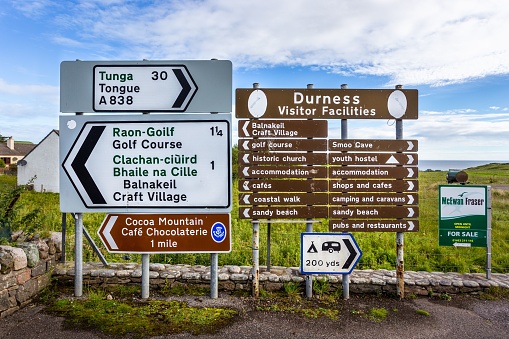 Durness, United Kingdom – August 23, 2022: A collection of four directional signs set up on the side of the road in Durness, United Kingdom