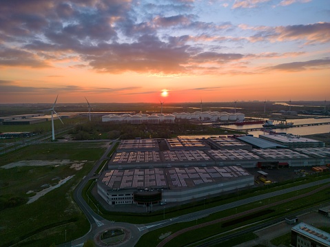 An aerial of a sprawling industrial estate adorned with a massive storage warehouse at sunset.