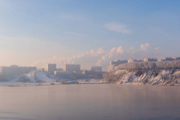 zimowy krajobraz z dużym zbiornikiem wodnym z dymem unoszącym się z miasta w tle - moscow river zdjęcia i obrazy z banku zdjęć