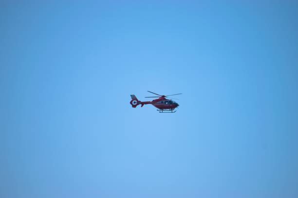 istock Modern helicopter flying in the sky with a clear blue sky background 1492802401