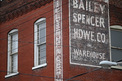 Lynchburg, United States – March 12, 2023: A closeup of an old building with an old advertisement on the wall