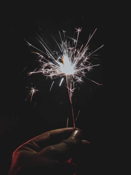 istock Hand illuminated by the light of a sparkler at night, creating a captivating scene 1492803557