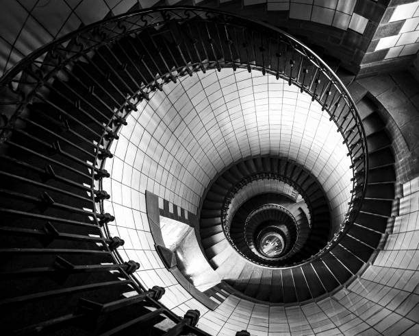 istock Grayscale high angle shot of a curving spiral staircase in a building 1492803621