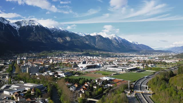 Aerial footage over a cityscape with traffic cars and mountains landscape in Innsbruck, Austria