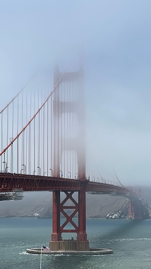 An aerial view of the iconic  Golden Gate Bridge shrouded in a dense fog