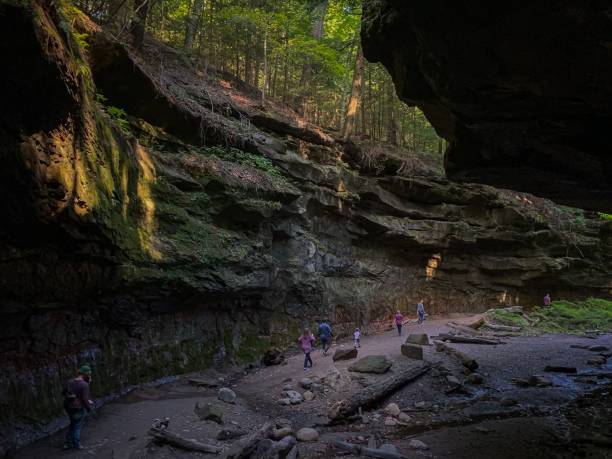 istock people walking in a cave at night on some rocks and trees 1492808061
