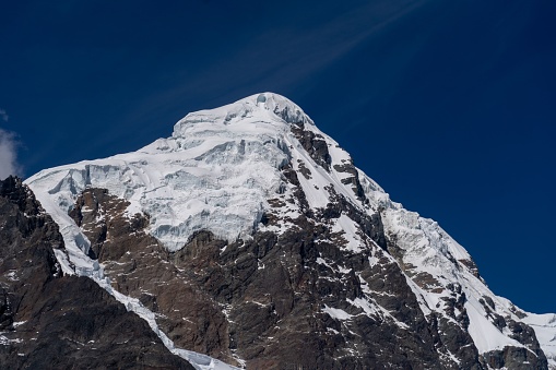 A snow-covered mountain peak under a blue sky in Peru.