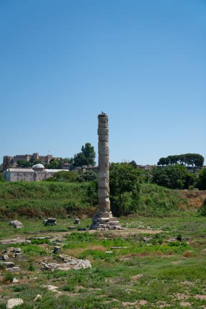 istock Beautiful Turkish ancient pillar still standing tall on grass against a blue sky 1492810289