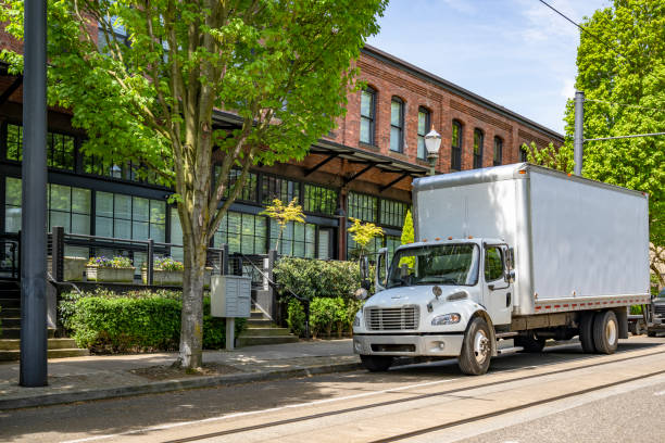 istock Moving business middle rig semi truck with big box trailer loading customers goods standing on the city street near the apartment 1492810894