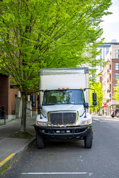 istock Powerful middle duty day cab rig semi truck transporting cargo in box trailer standing on the city street unloading goods 1492811509