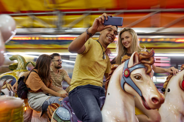 istock Happy couple taking a selfie during carousel ride at amusement park. 1492812733