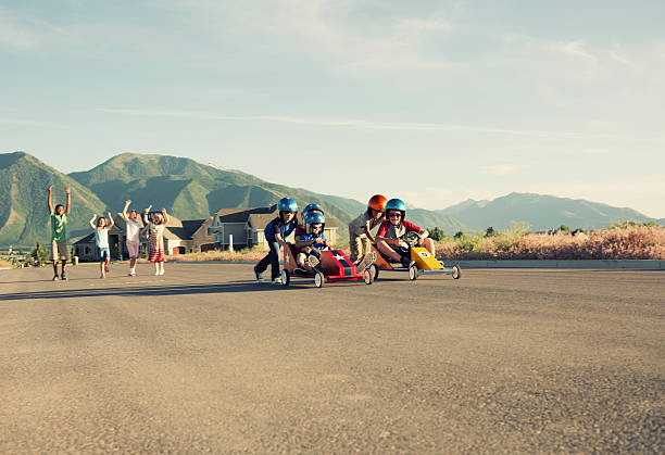 Yippee! And they are off. A group of young neighborhood boys hit the streets in the soap box racers. soapbox cart stock pictures, royalty-free photos & images