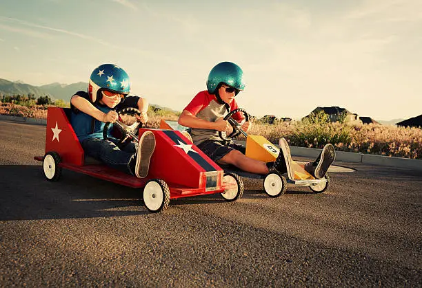 Two boys from the neighborhood hit the streets for the go-cart championship.