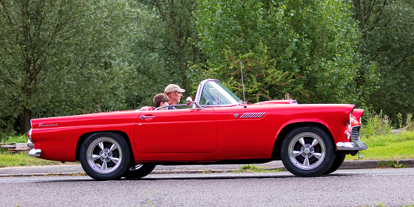 Stony Stratford, Bucks, UK Aug 29th 2021.  1955 red FORD THUNDERBIRD  classic car travelling on an English country road