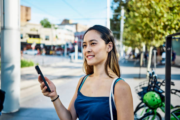 urban commuter : une jeune femme asiatique navigue dans la ville avec son téléphone - bus public transportation sydney australia australia photos et images de collection