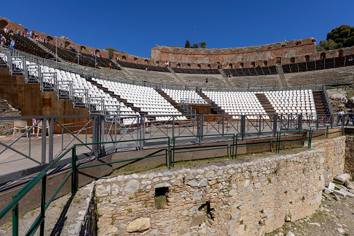 Taormina, Sicily, Italy - April 28, 2023: Ancient theatre of Taormina (Teatro antico di Taormina), ruins of ancient Greek theatre, built in Hellenistic era with a view of Mount Etna volcano