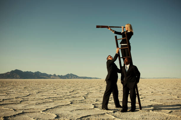 kleine business-team suche durch ein teleskop auf salt flats - langes haar stock-fotos und bilder