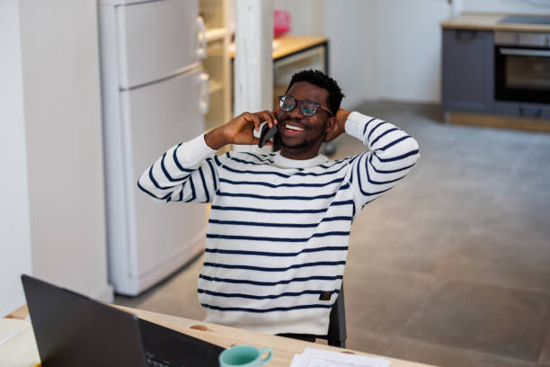 istock A young business African man is working at home while using a mobile phone for communication. 1492825384
