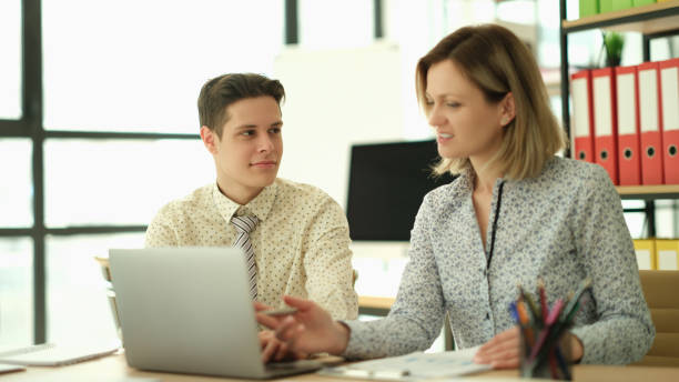 istock Woman manager teaching trainee how to work on laptop in office 1492826191