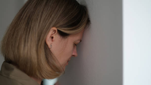 zmęczona, przygnębiona kobieta głową w ścianę - banging your head against a wall obrazy zdjęcia i obrazy z banku zdjęć