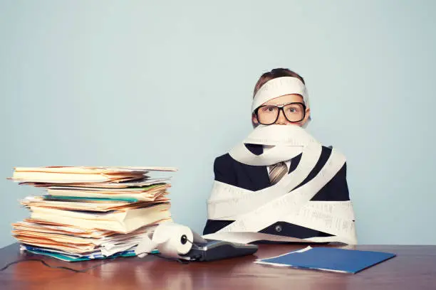 Photo of Boy Accountant Overworked and Covered in Paper