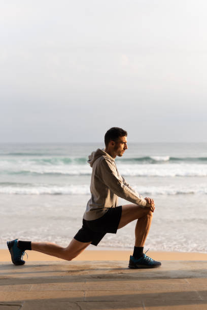 istock Sportsman stretching legs at the beach 1492828758