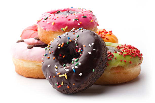 A pile of glazed doughnuts with sprinkles Group of glazed donuts, isolated on white background donuts stock pictures, royalty-free photos & images