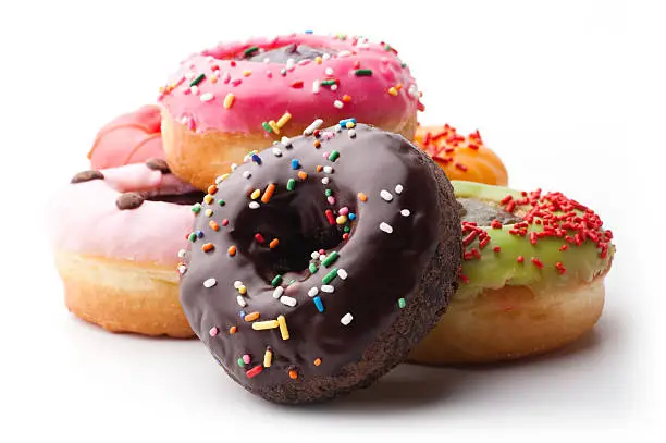 Photo of A pile of glazed doughnuts with sprinkles