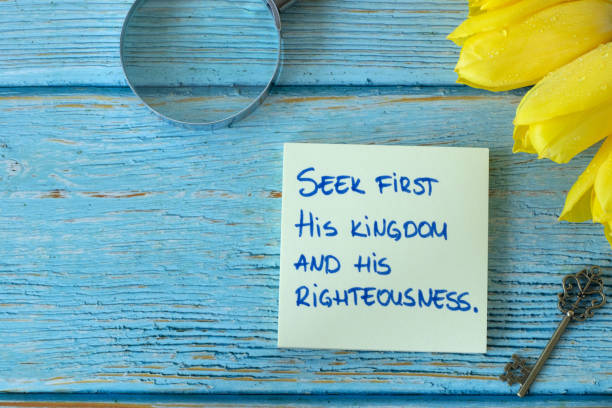 istock Seek first His kingdom and righteousness, handwritten biblical verse on note with ancient key, magnifying glass, and yellow tulips on wood 1492830682