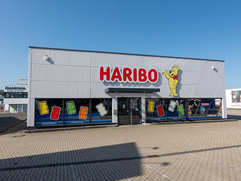 Mulheim-Karlich, Germany - May 18, 2023:: entrance and facade of the Haribo Outlet Store with the famous yellow Haribo bear. Haribo is a German confectionery company