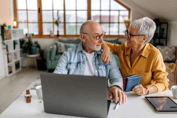 istock Senior couple making online reservation using laptop at their home 1492831728