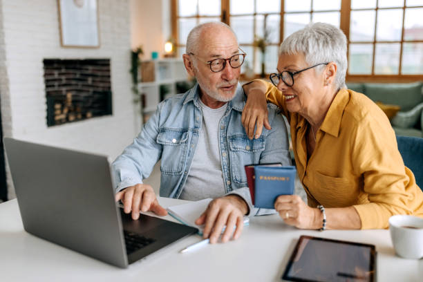 istock Senior couple making online reservation using laptop at their home 1492831765