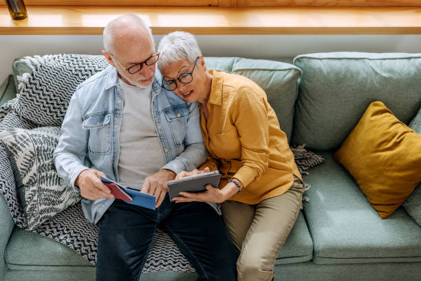 istock Senior couple using digital tablet to make a online reservation for their vacation 1492832392