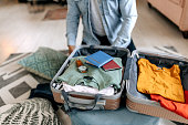 Unrecognisable senior man packing suitcase for vacation at home