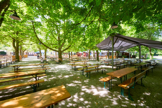 Schöner Biergarten in München Bayern mit schönen Kastanienbäumen im Sommer.
